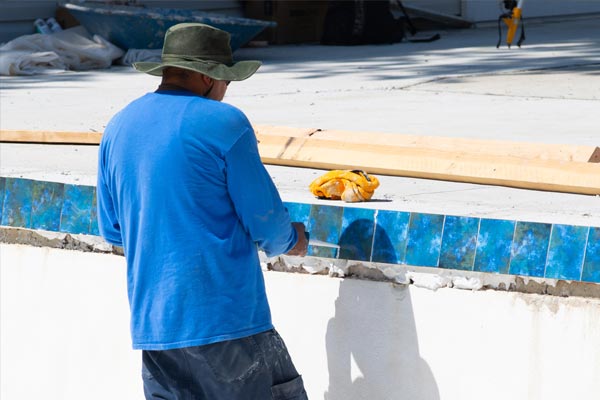 This shows an image of a man putting pool tiles.